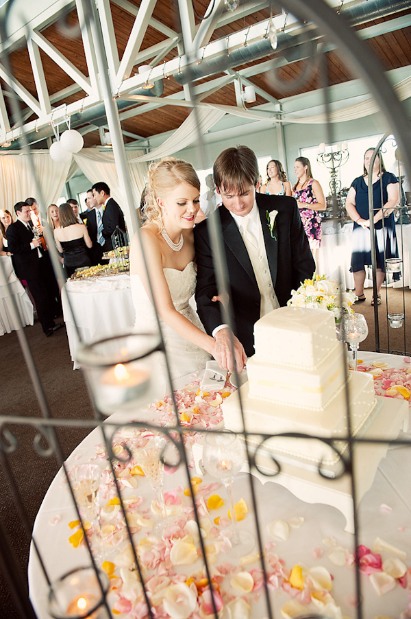 the happy couple cutting the cake at the reception - photo by Houston based wedding photographer Adam Nyholt 